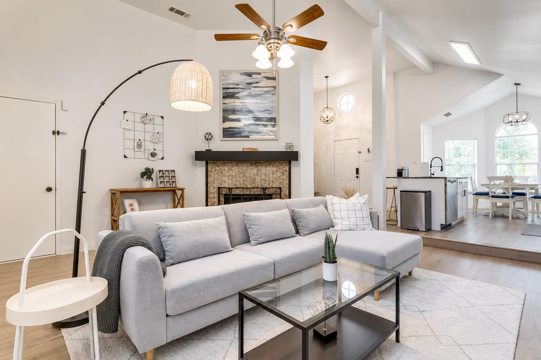 A bright, furnished living room with a vaulted ceiling, prepared to a hospitality standard for a 30+ day stay.